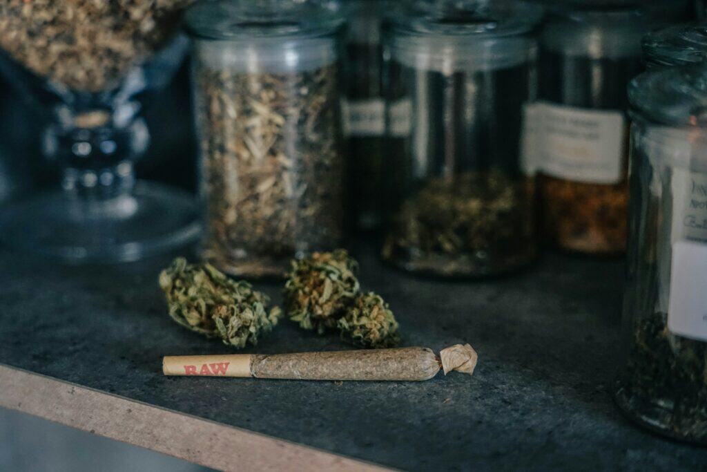 Blood Moon cannabis buds and jars of dried herbs on a countertop.